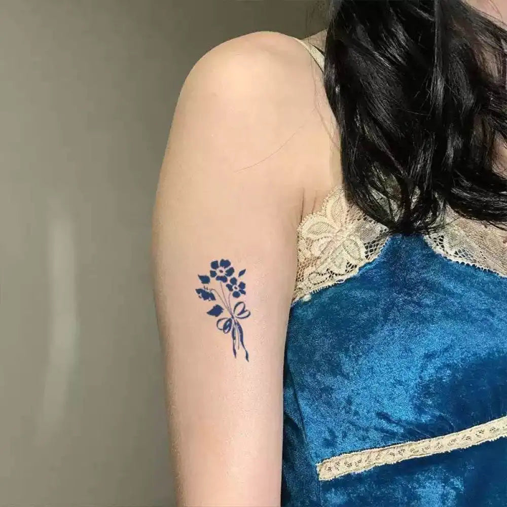 Woman’s arm with blue floral tattoo sticker from Elegant Bows Bouquet advanced hand-drawn design