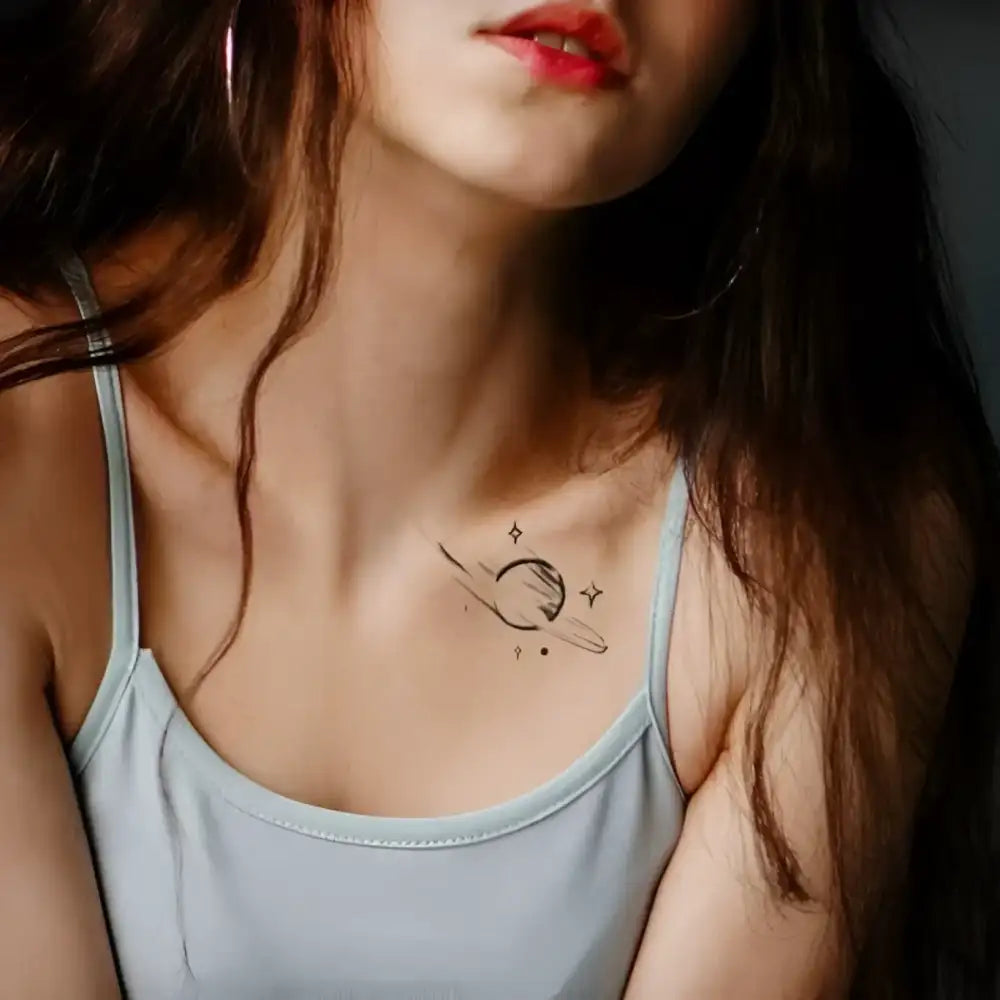 Woman’s upper body with a semi-permanent planet tattoo sticker on collarbone, real reviews