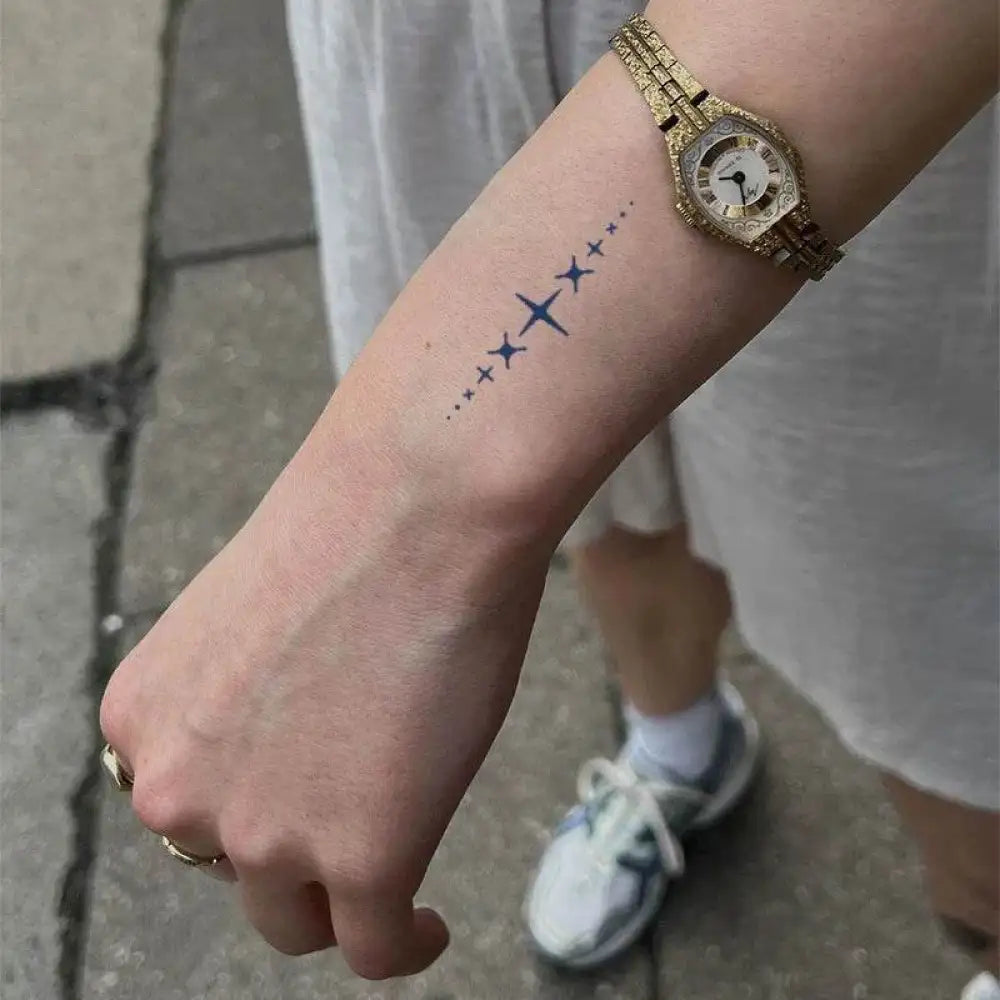 Forearm with star tattoo and watch showcasing advanced hand-drawn design tattoo sticker