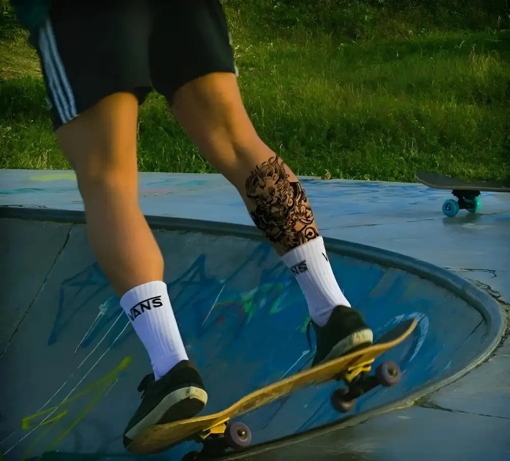 Person with Demon Slayer tattoo sticker skateboarding in skatepark