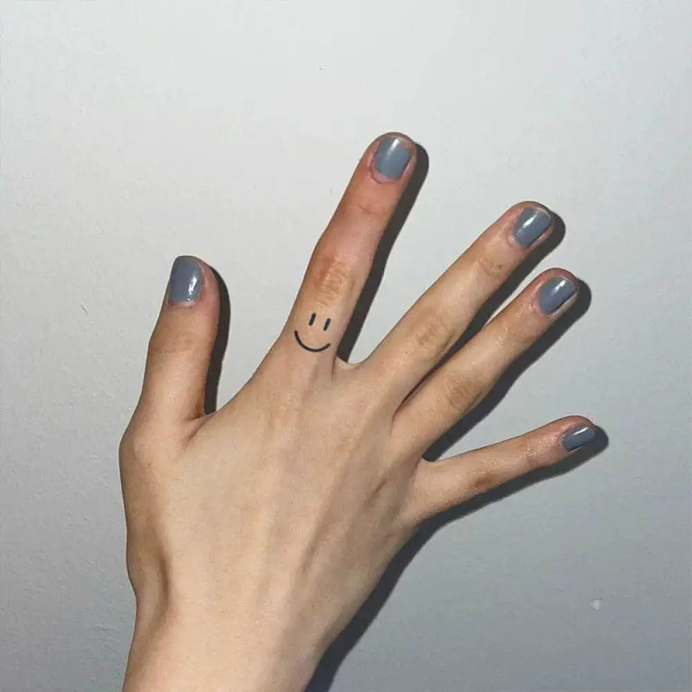 Hand with grey nail polish featuring a happy face and bow tie heart design in Hand Art Collection