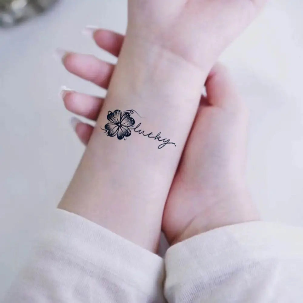 Black ink lucky clover and happy lucky clover tattoo sticker on wrist display