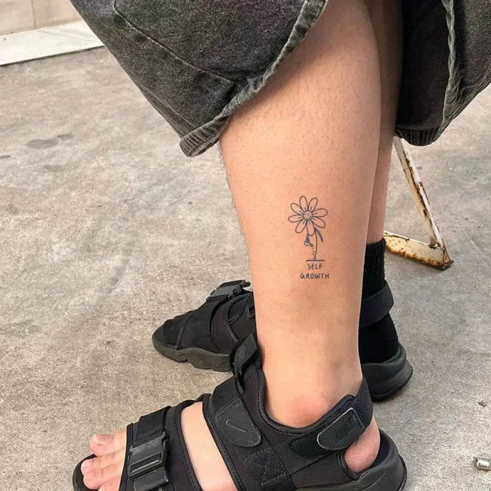 Lower leg with minimalist daisy tattoo sticker featuring advanced hand-drawn design and real reviews