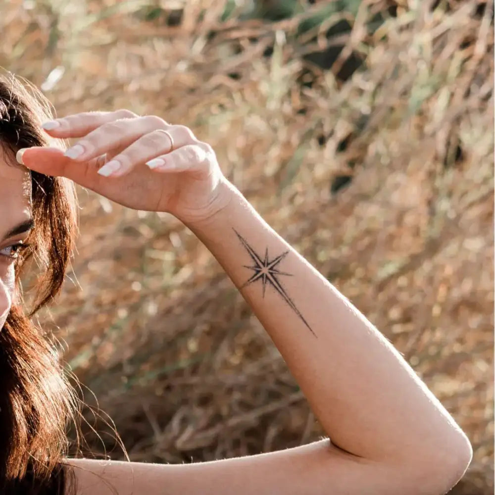 Woman’s forearm with a minimalist North Star tattoo sticker from Starlight
