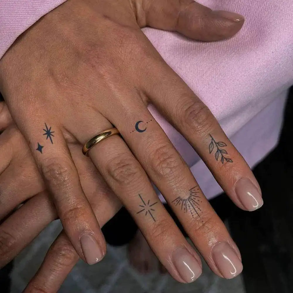 Hands with small tattoos and a gold ring from the Celestial Tattoo Sticker Collection Under Branches Light Moon