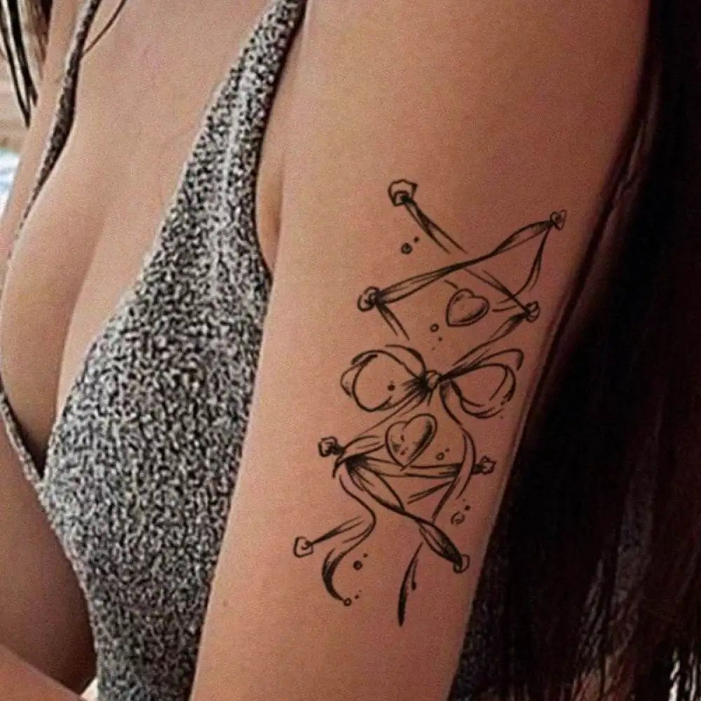 Woman’s arm with bow and heart corset tattoo sticker, butterfly clasp design