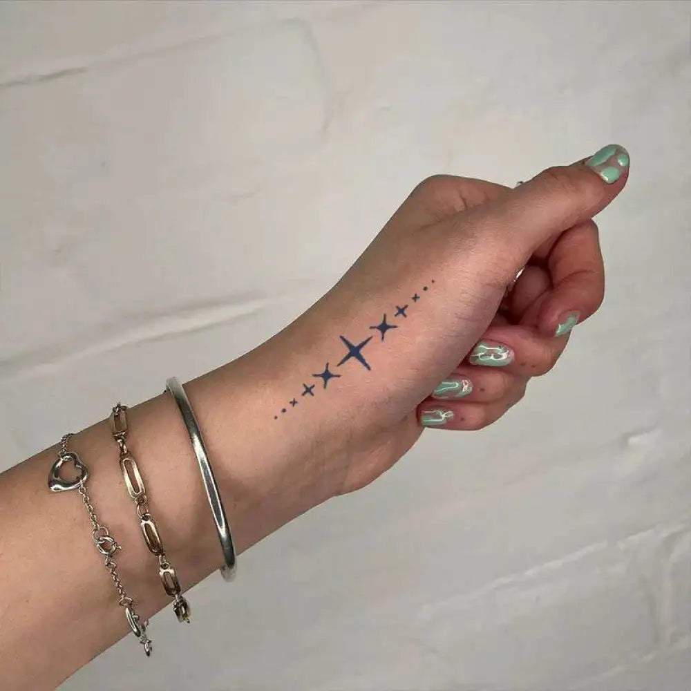Hand with star-patterned tattoo sticker, bracelets, light green nails, real reviews