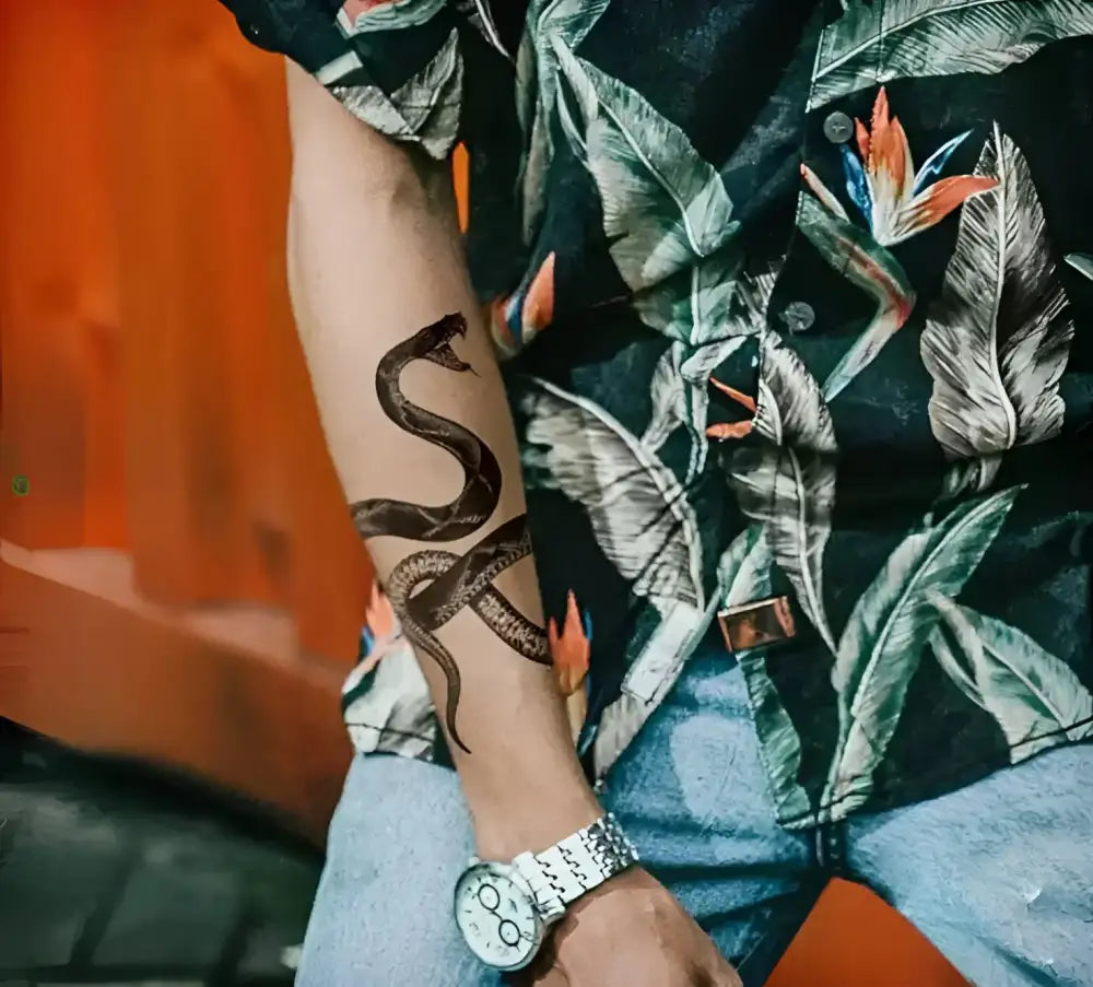 Person in tropical shirt and jeans with snake semi permanent tattoo on arm