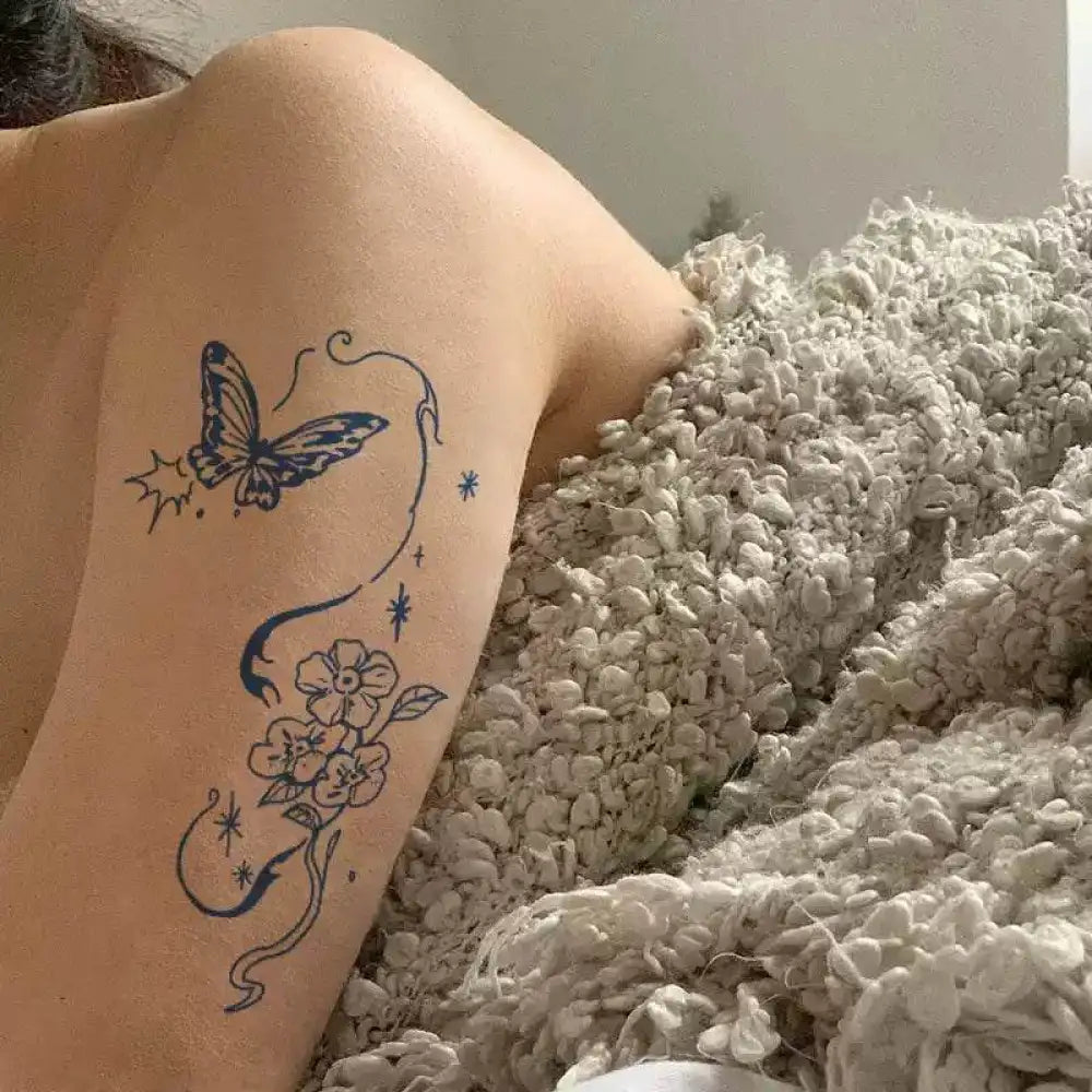 Ephemeral Bloom tattoo sticker featuring an arm with a blue butterfly and floral design