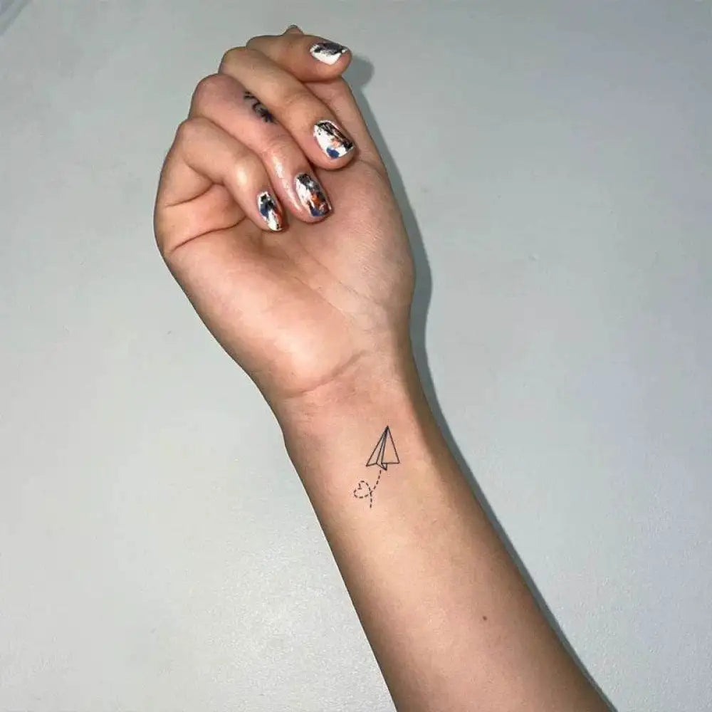 Forearm with bow tie heart tattoo and iridescent nail polish from Whimsical Bow Tie Heart collection