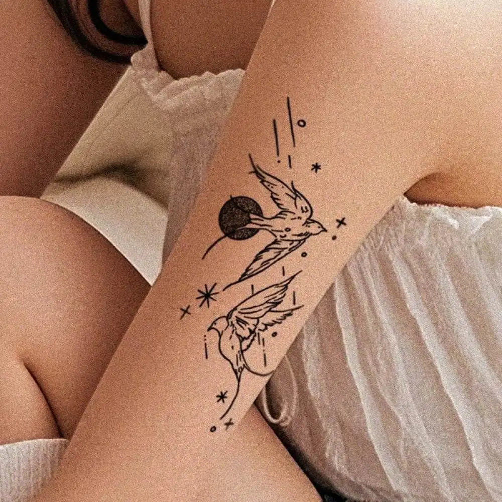 Black ink swallow and star tattoos on arm featuring happy flying birds design