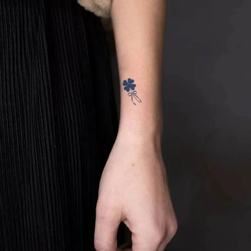 Delicate blue four-leaf clover tattoo sticker with ribbon design on wrist, real reviews