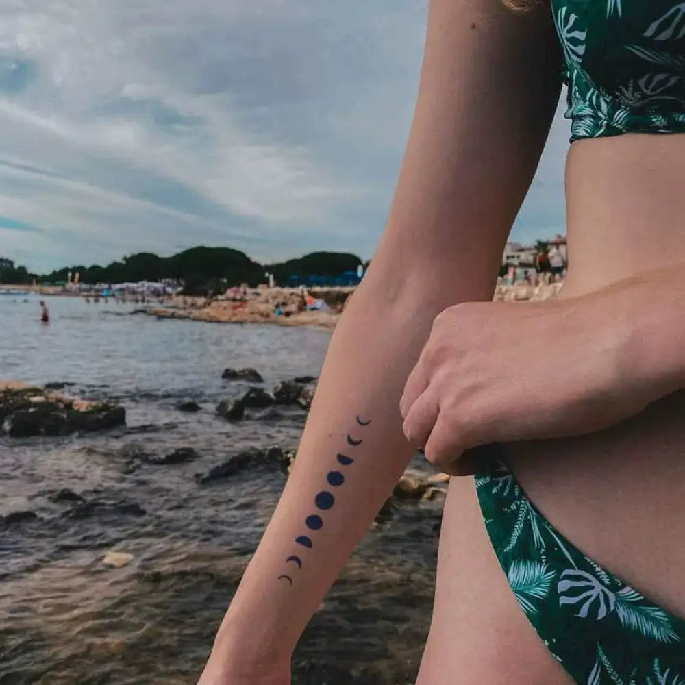 Woman’s arm with moon phase tattoo sticker featuring real reviews from women